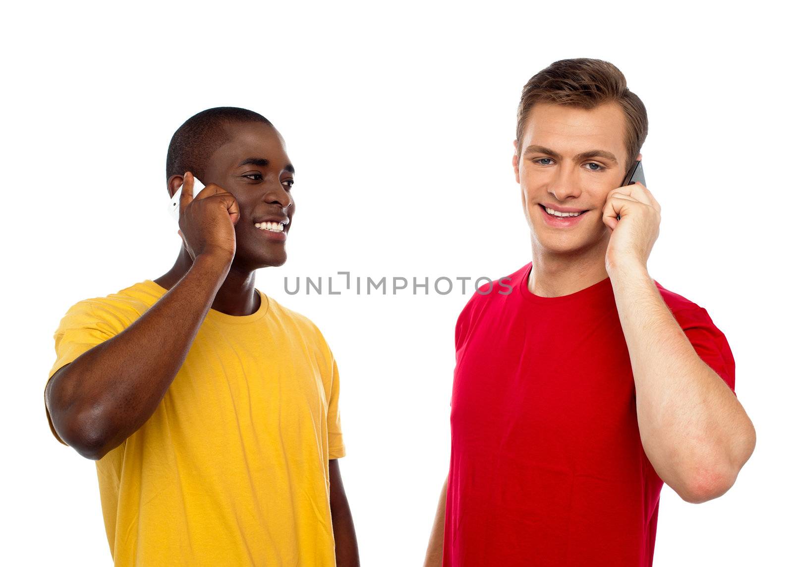 Two handsome men communicating on cellphone. African guy looking at caucasian male.