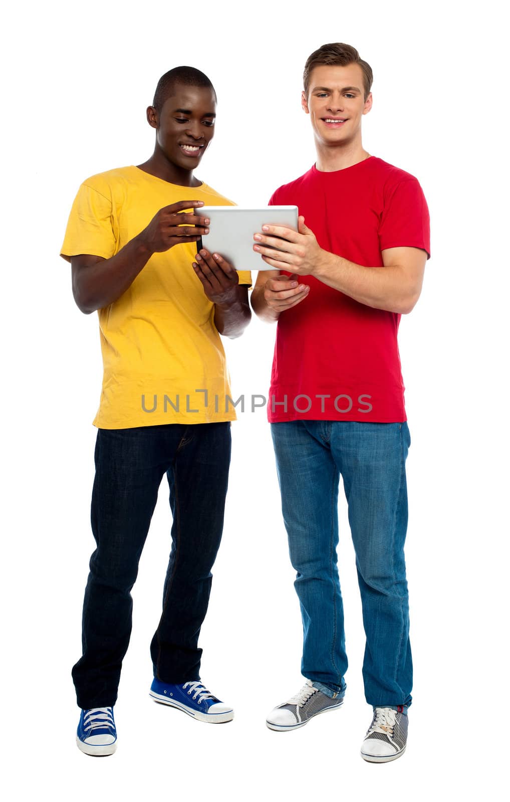 Full length shot of guys operating portable device against white background