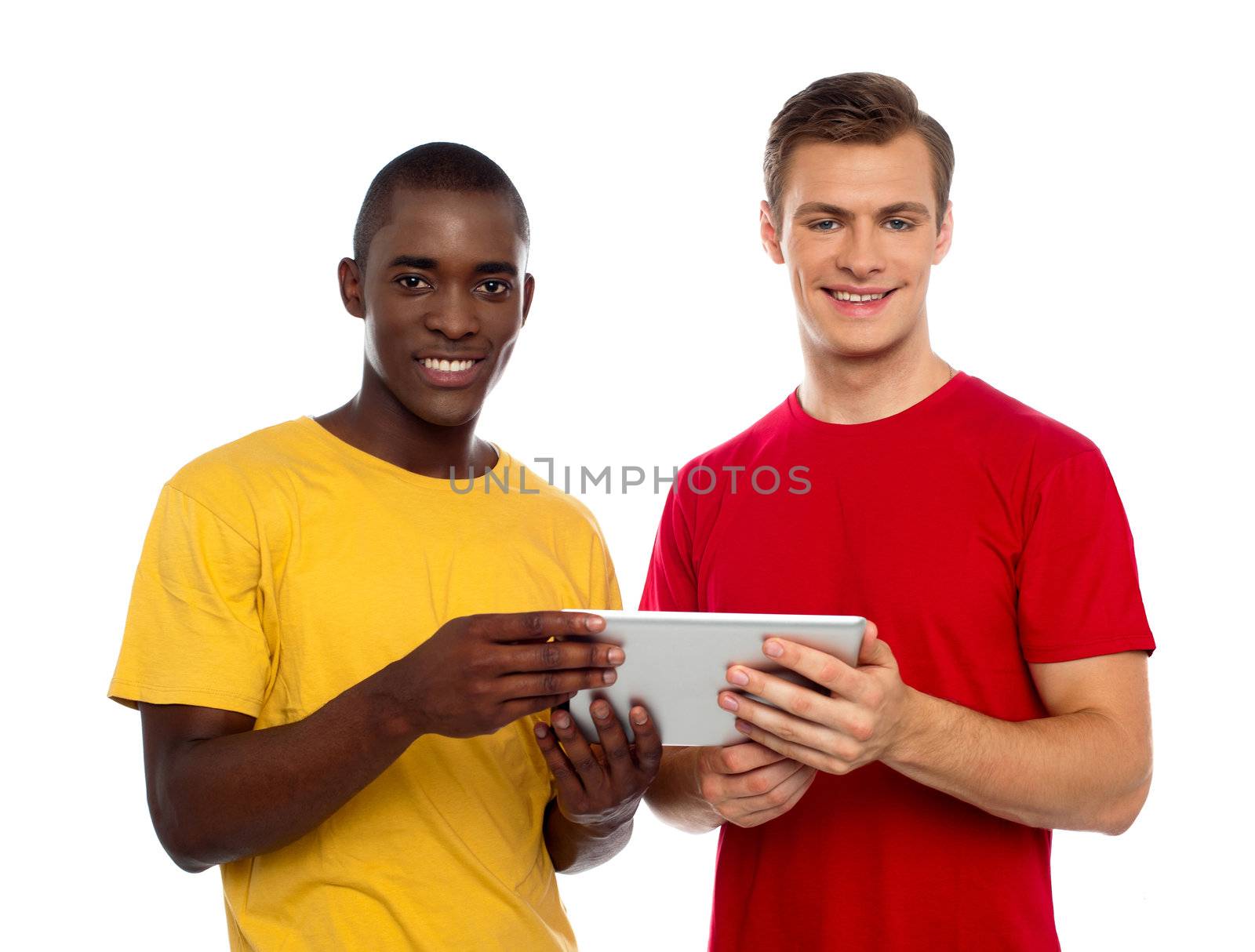Technology savvy friends using tablet pc and smiling at camera