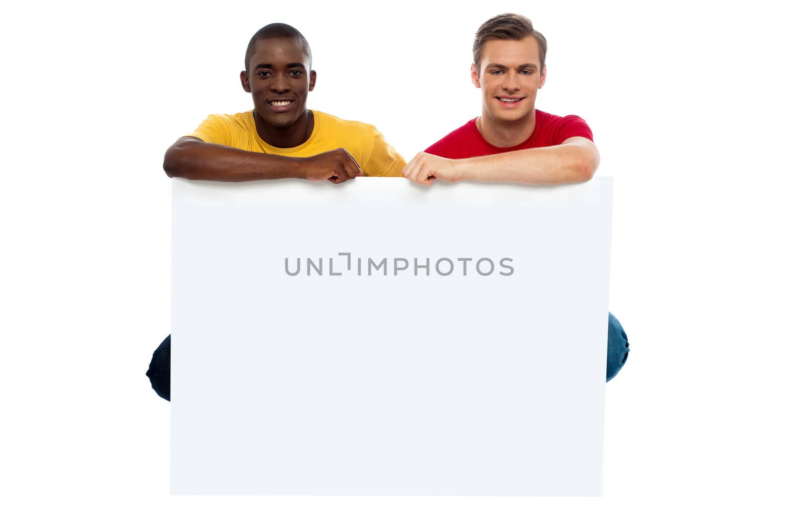 Casual young guys posing with blank billboard isolated against white background