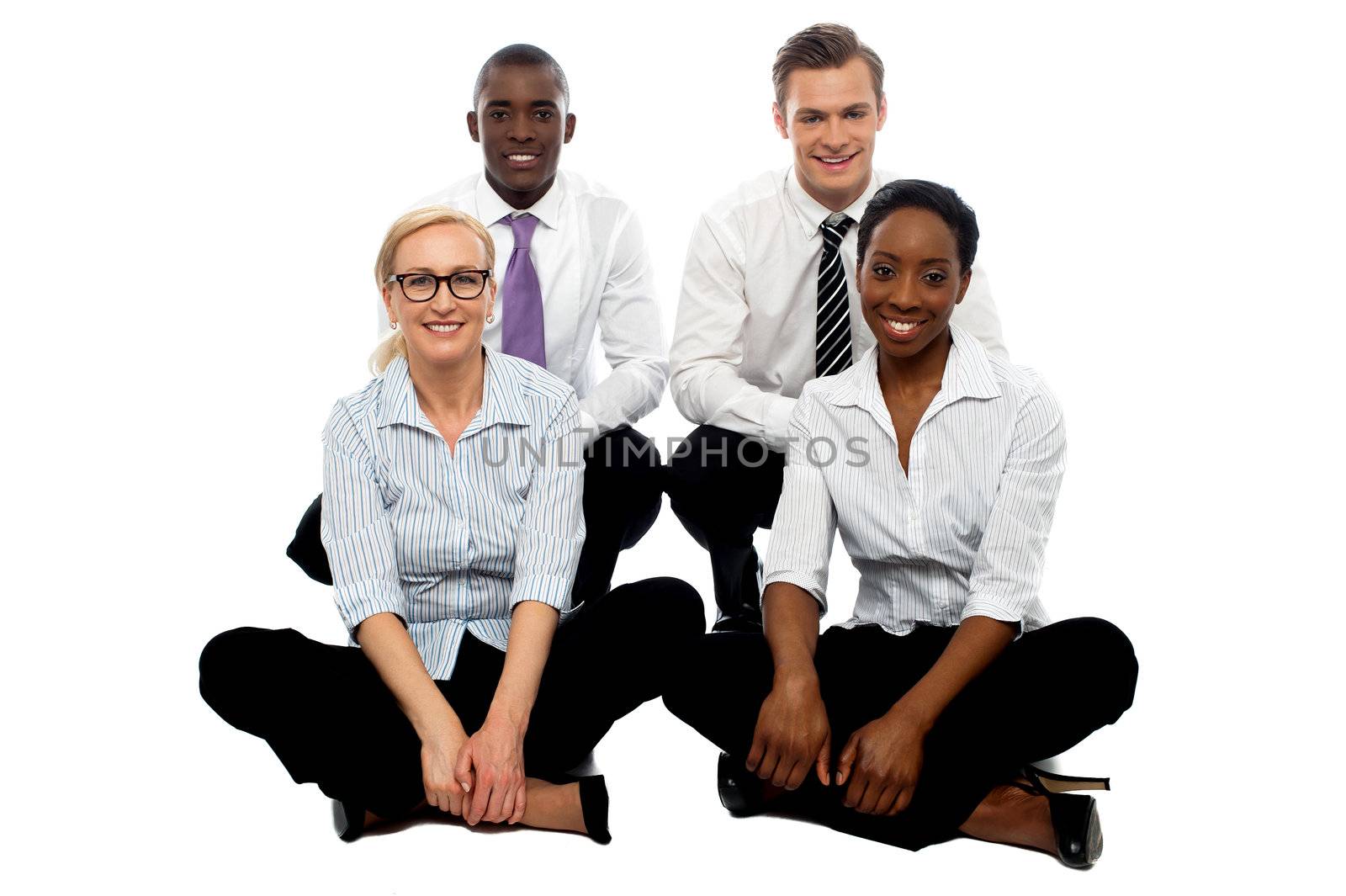 Four business colleagues sitting on floor, studio shot