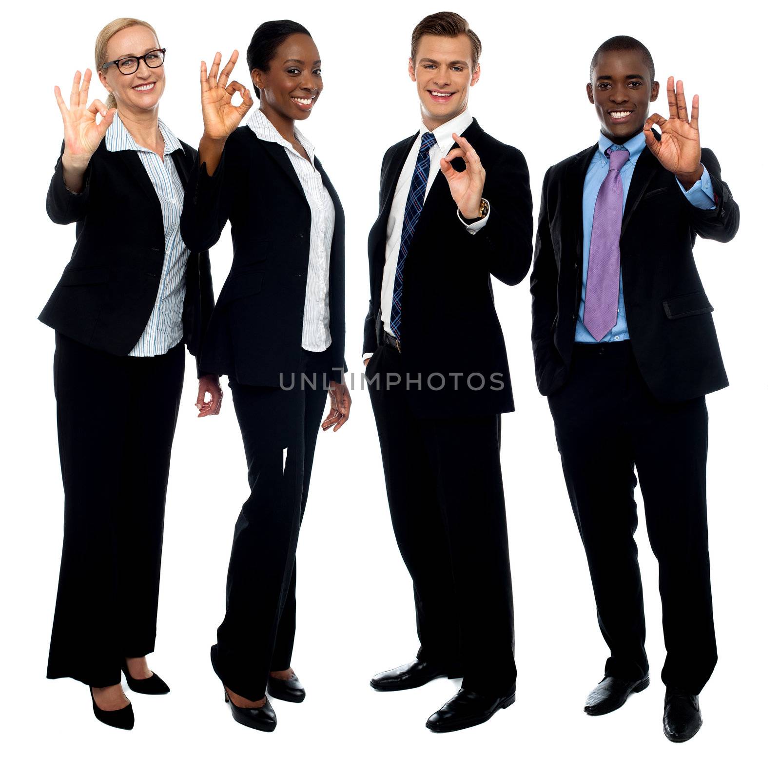 Successful corporate team showing ok symbol by stockyimages