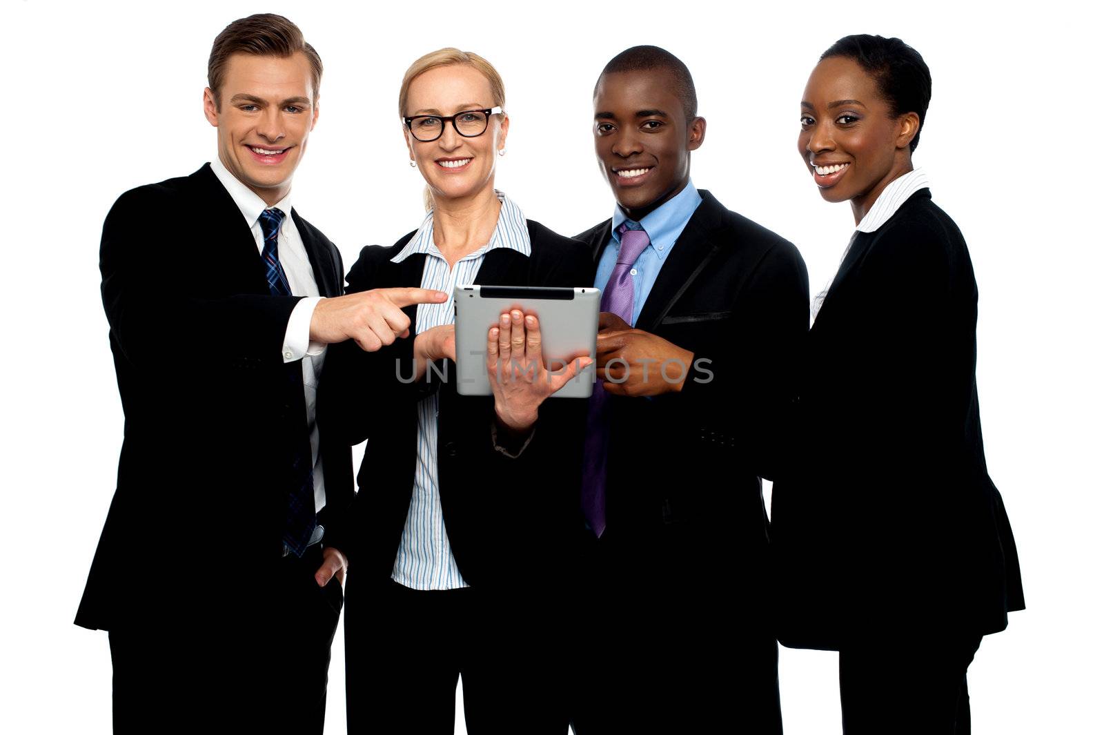 Business people pointing towards wireless tablet and smiling at camera