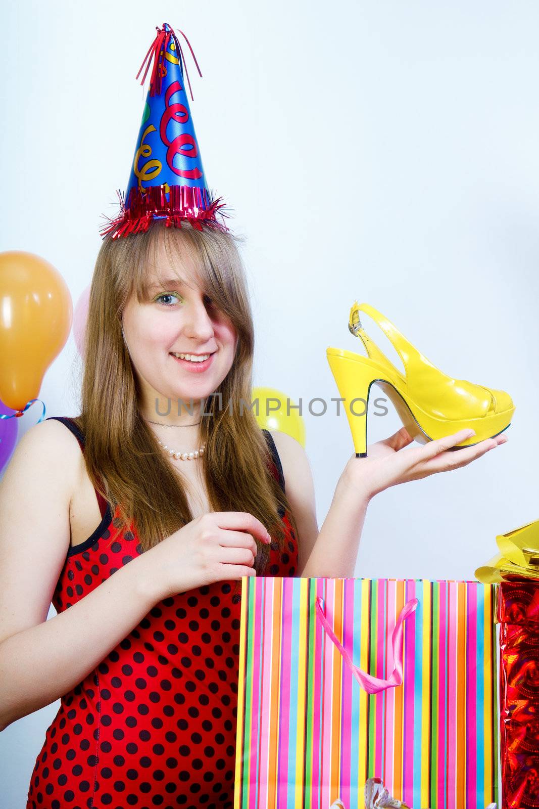 Birthday. Happy attractive girl unpacks the gift of shoes