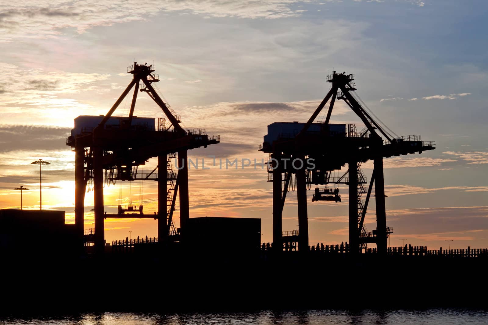 silhouette of Industrial ship in Terminal port with sunrise