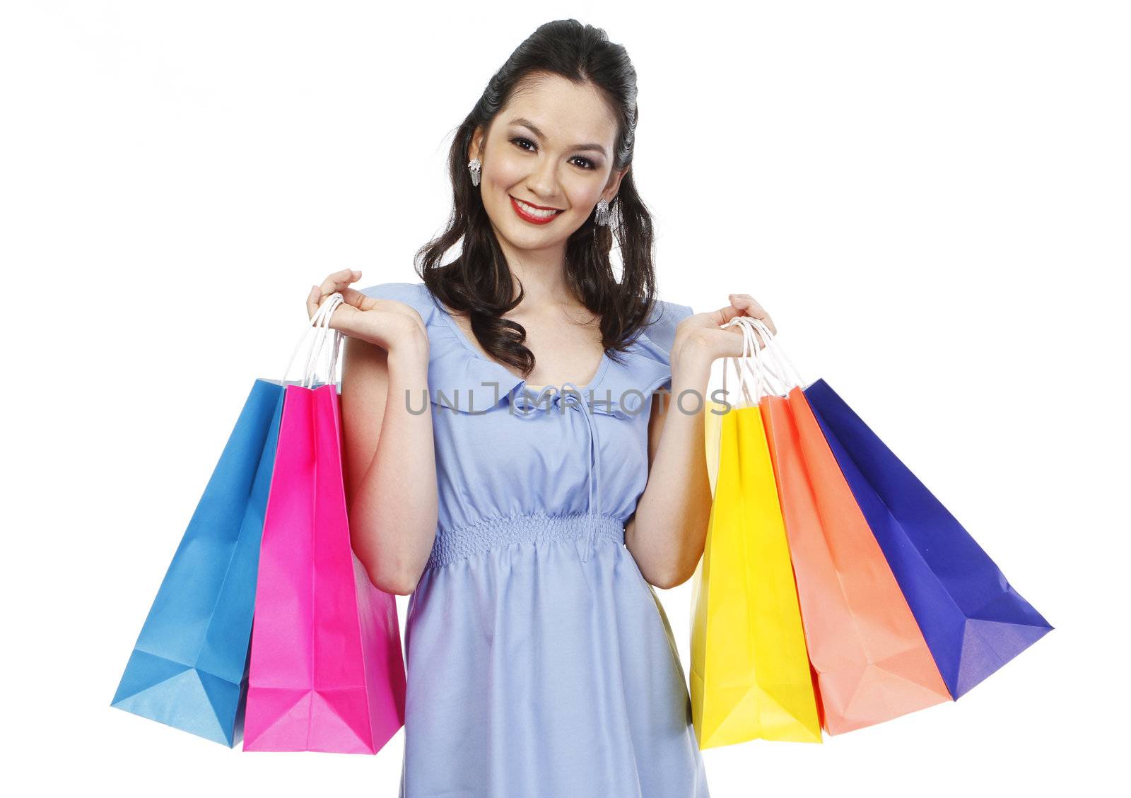 An attractive fashionable woman holding colorful paper shopping bags (isolated on white)