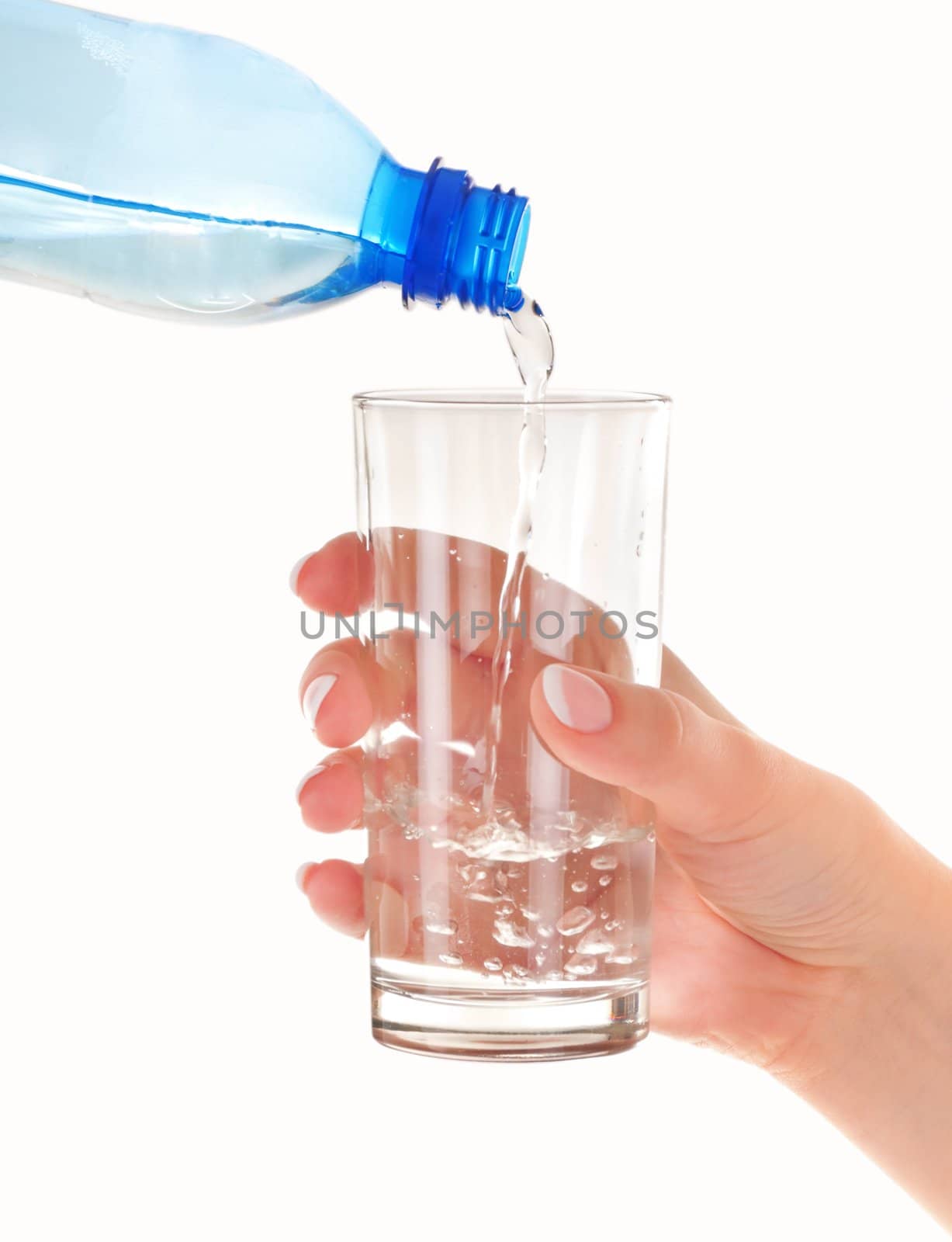 Glass in female hand is pouring from plastic blue bottle by clean water. On white background