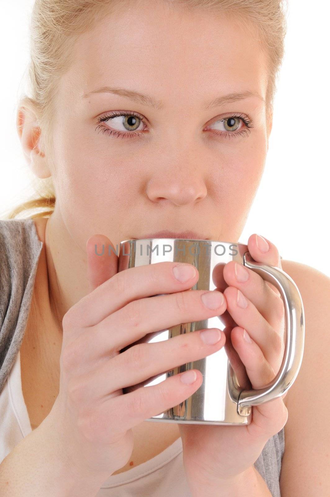 Casual blonde girl with metal cup is drinking hot beverage