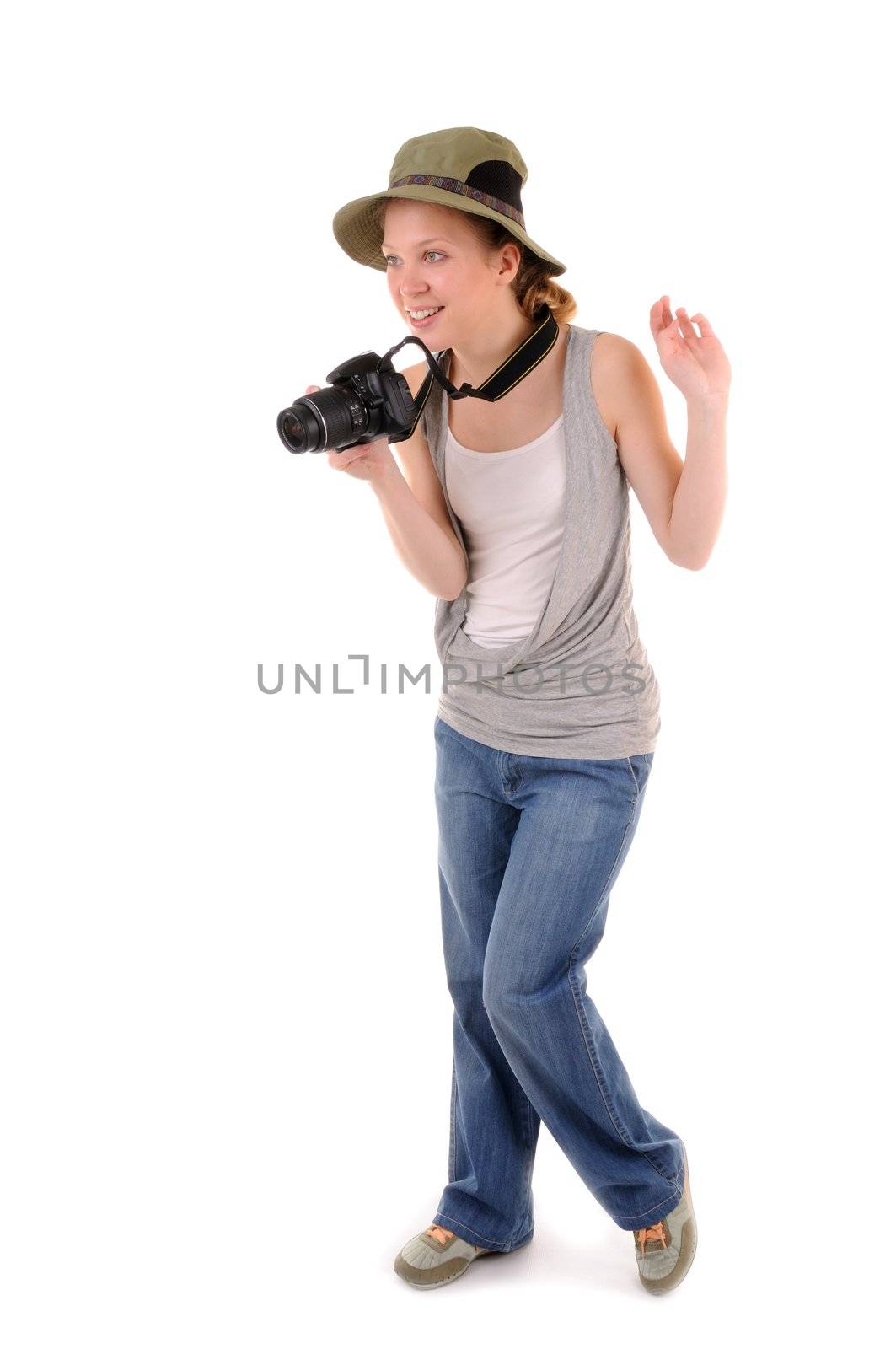 Standing casual smiling girl-tourist with digital photocamera is looking for picture on white background