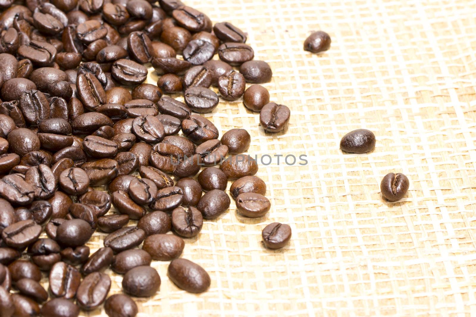 Fresh roasted coffee beans on light textured surface