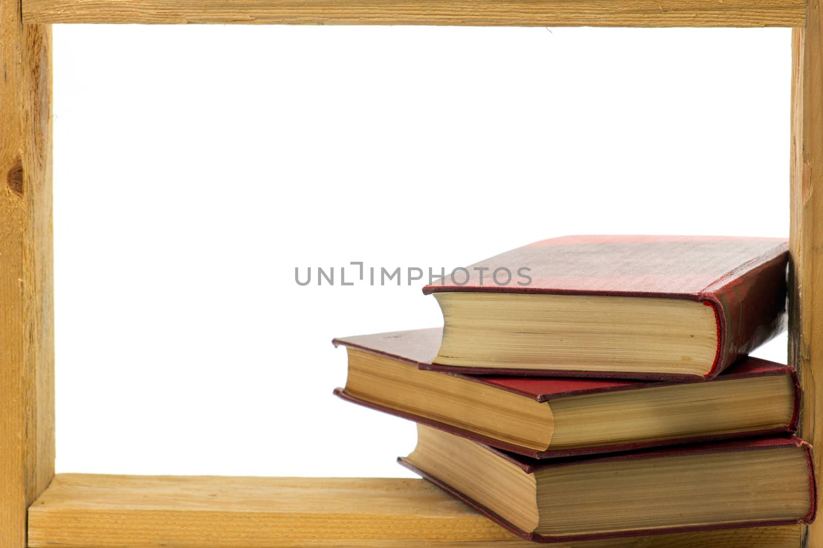 Some books with hard dark red covers in a wooden frame on white background