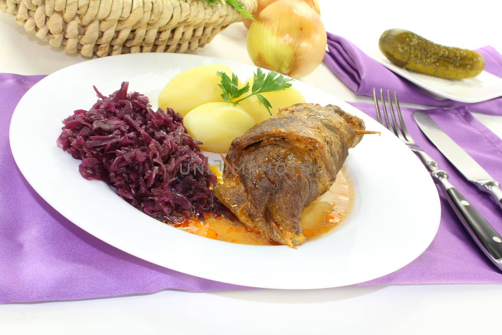 stuffed Beef roulade with bacon, onion and pickled cucumber on a light background