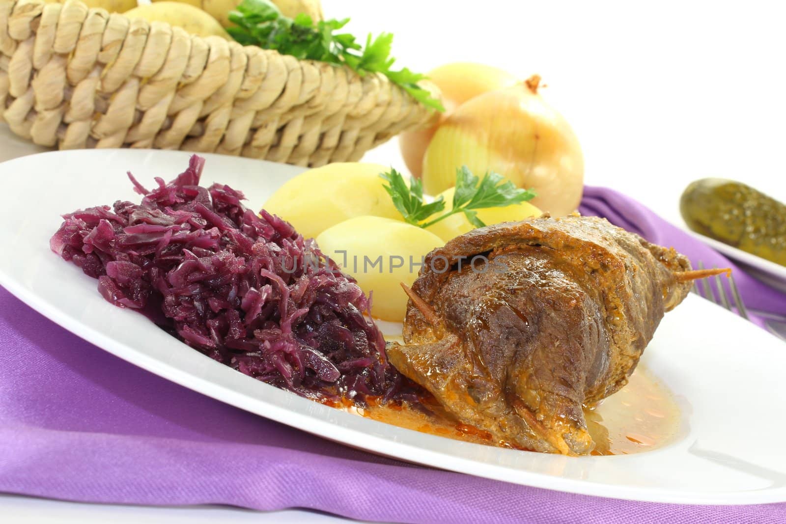 stuffed Beef roulade with potatoes and red cabbage on a bright background