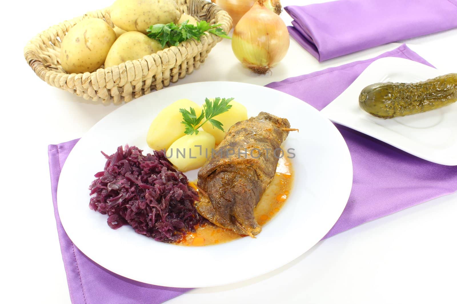 fresh stuffed Beef roulade with potatoes and red cabbage on a light background