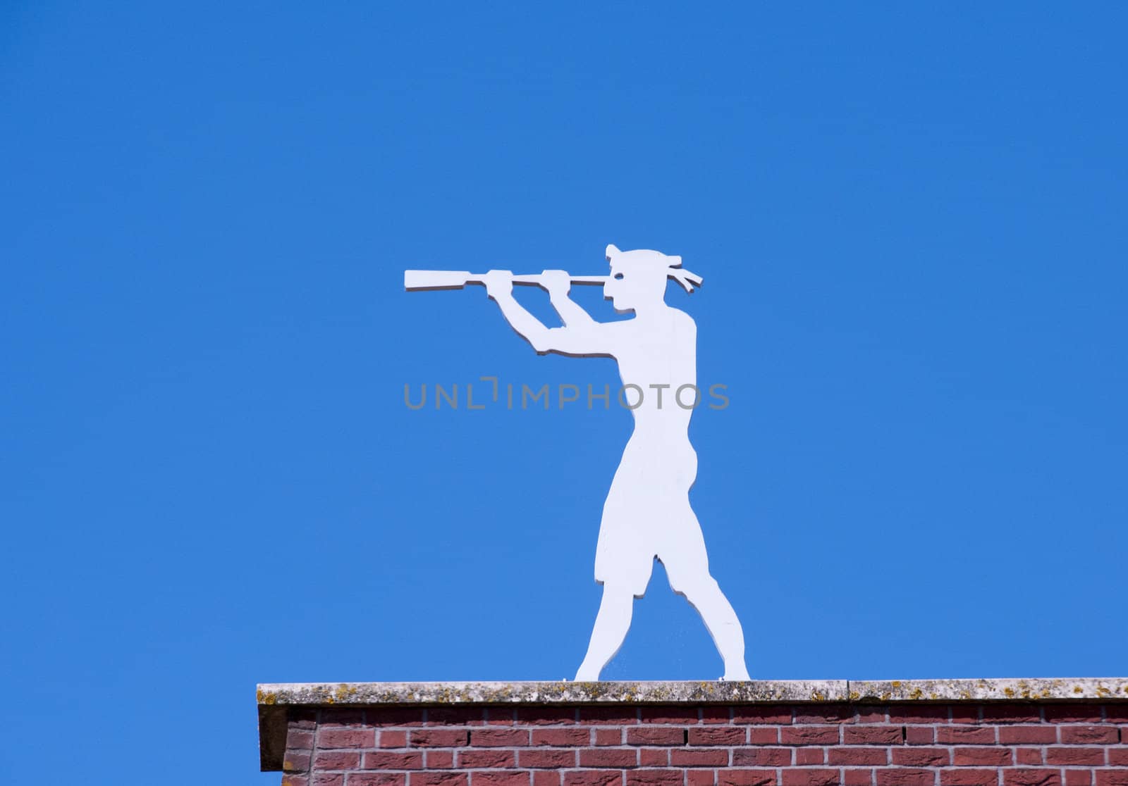 man on a roof looking with binoculars and a blue sky as background