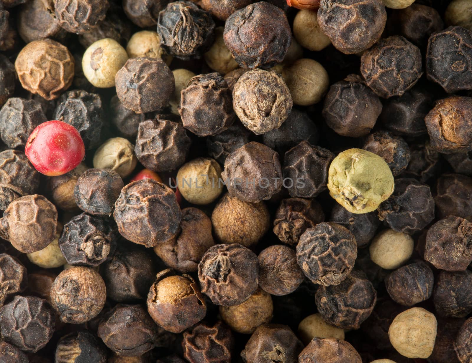 Mixed red, white and black pepper corn seeds in macro photo