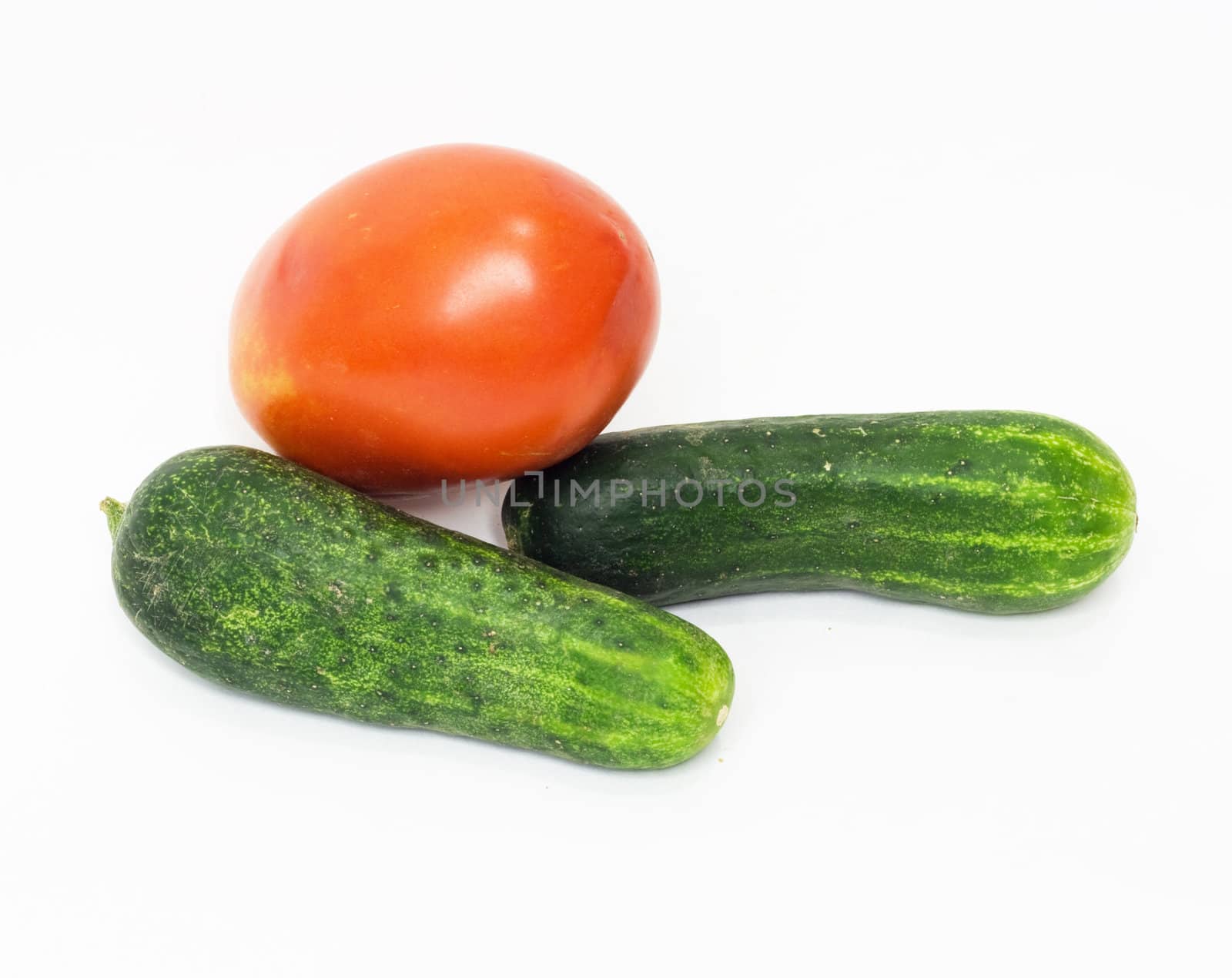 red tomato and cucumber together on a white background  by schankz