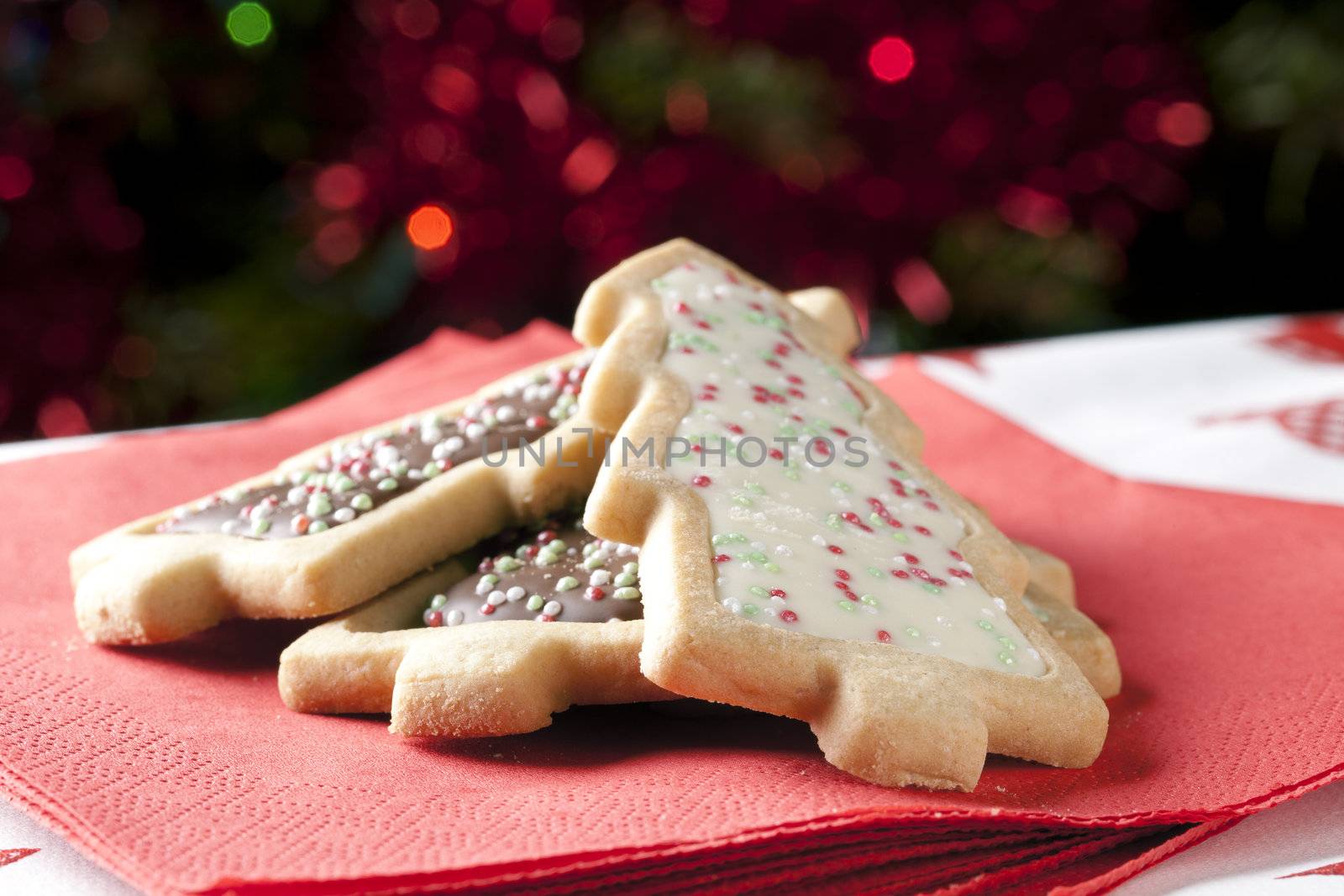 Tree shaped Christmas cookies on a red napkin.