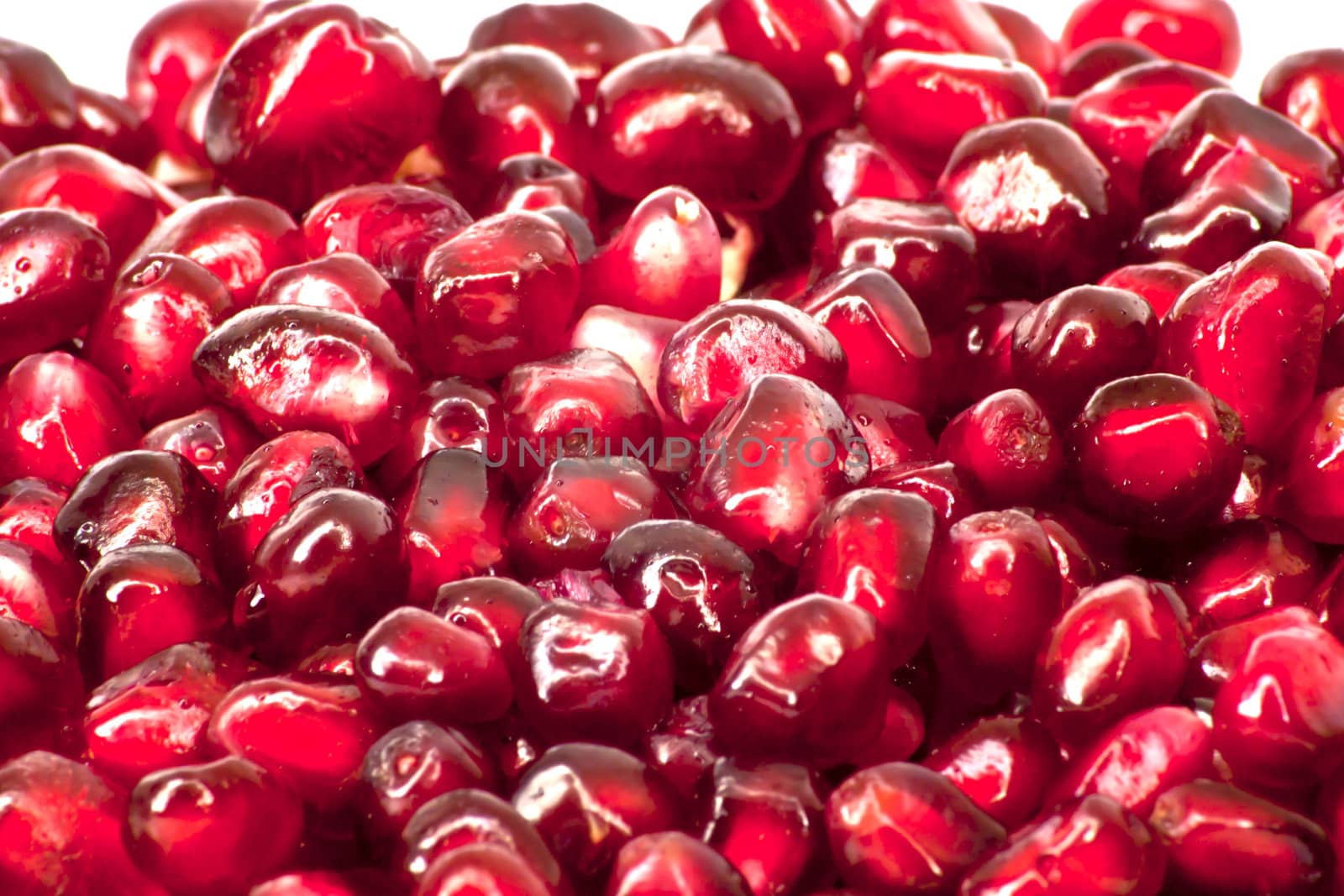 Extreme close up background of a red juicy ripe pomegranate fruit seeds 