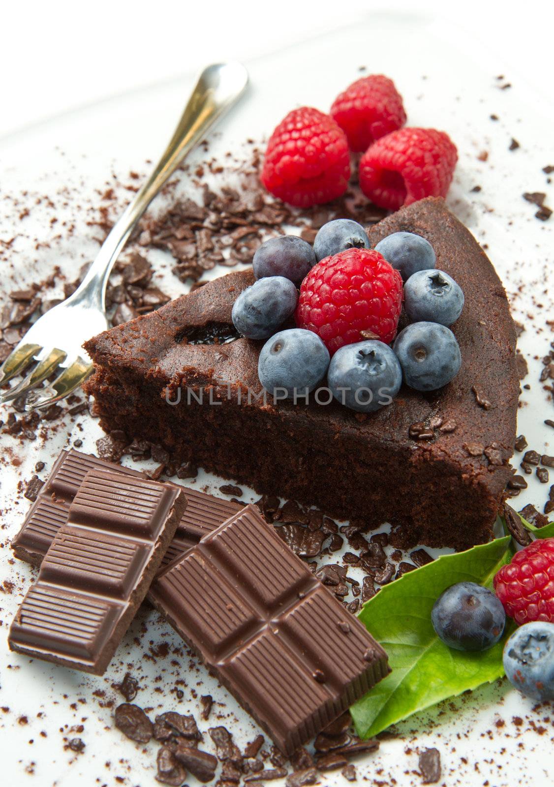 Piece of chocolate cake with fresh berry on white background 