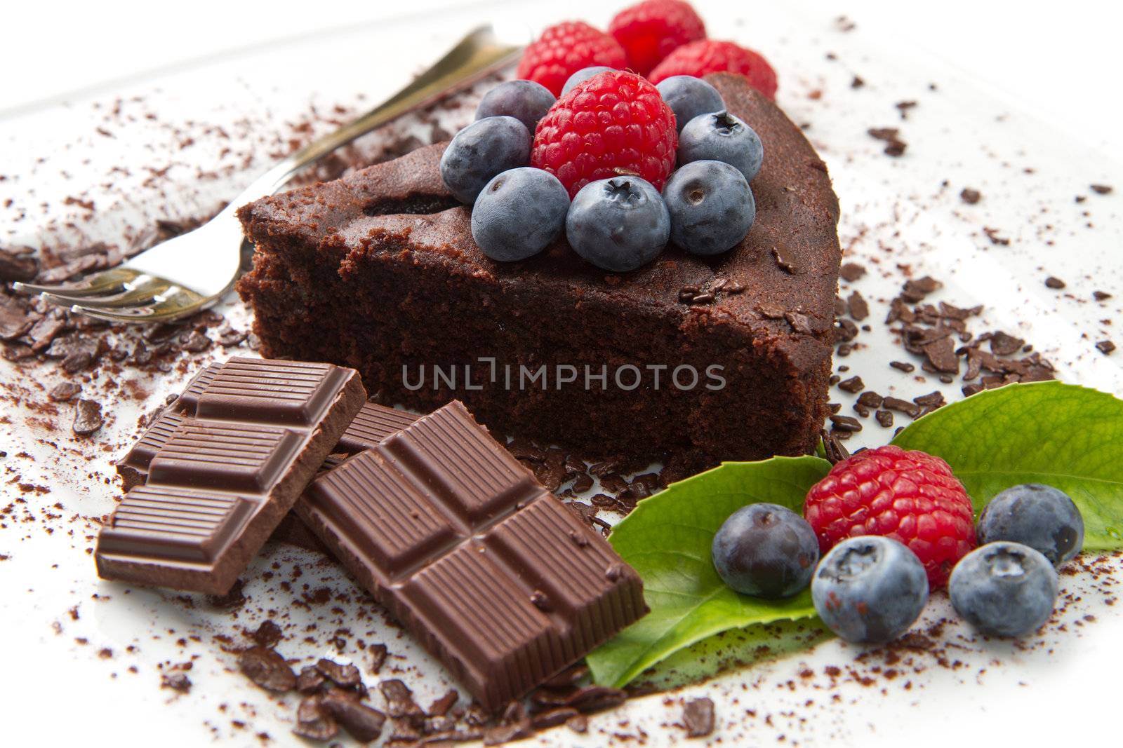 Piece of chocolate cake with fresh berry on white background 