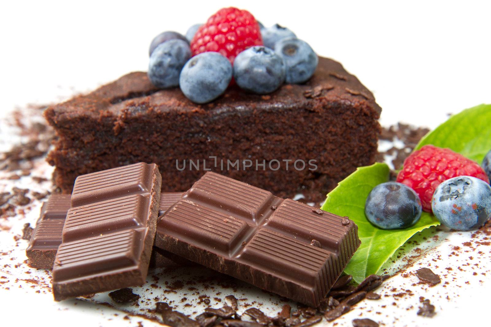 Piece of chocolate cake with fresh berry on white background 