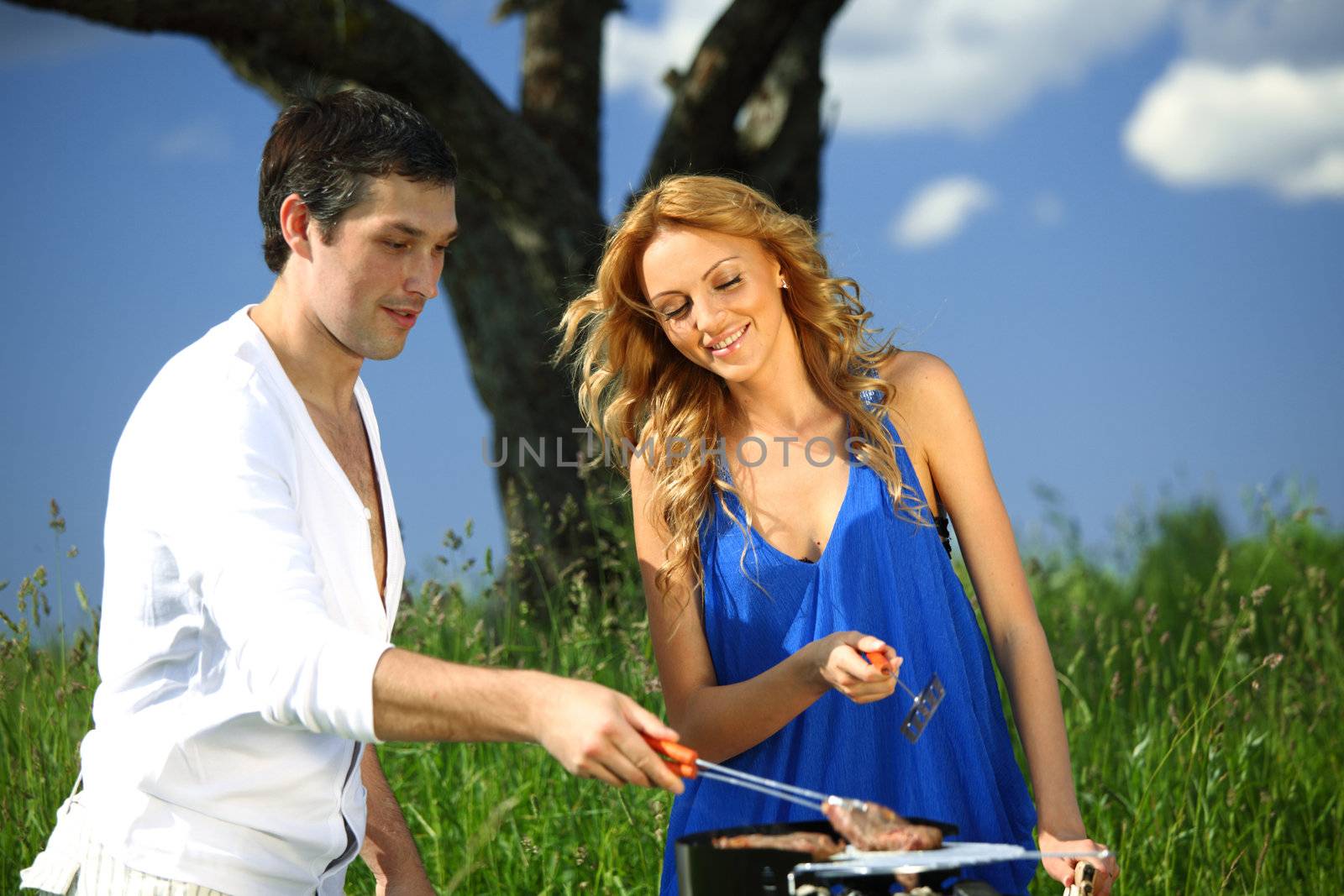 man and woman on picnic in green grass