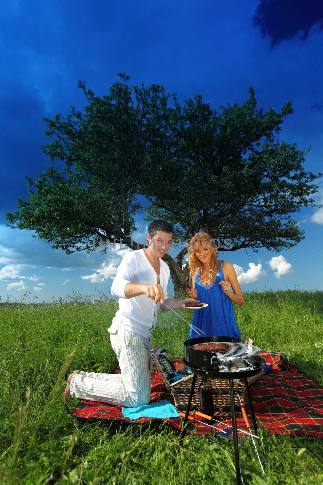 man and woman on picnic in green grass