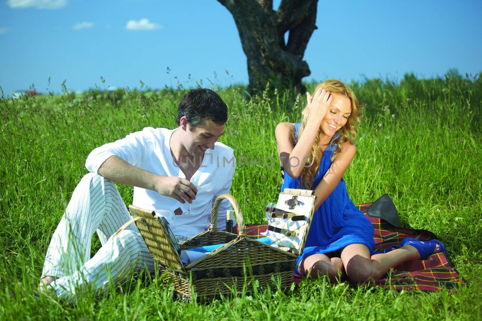 man and woman on picnic in green grass