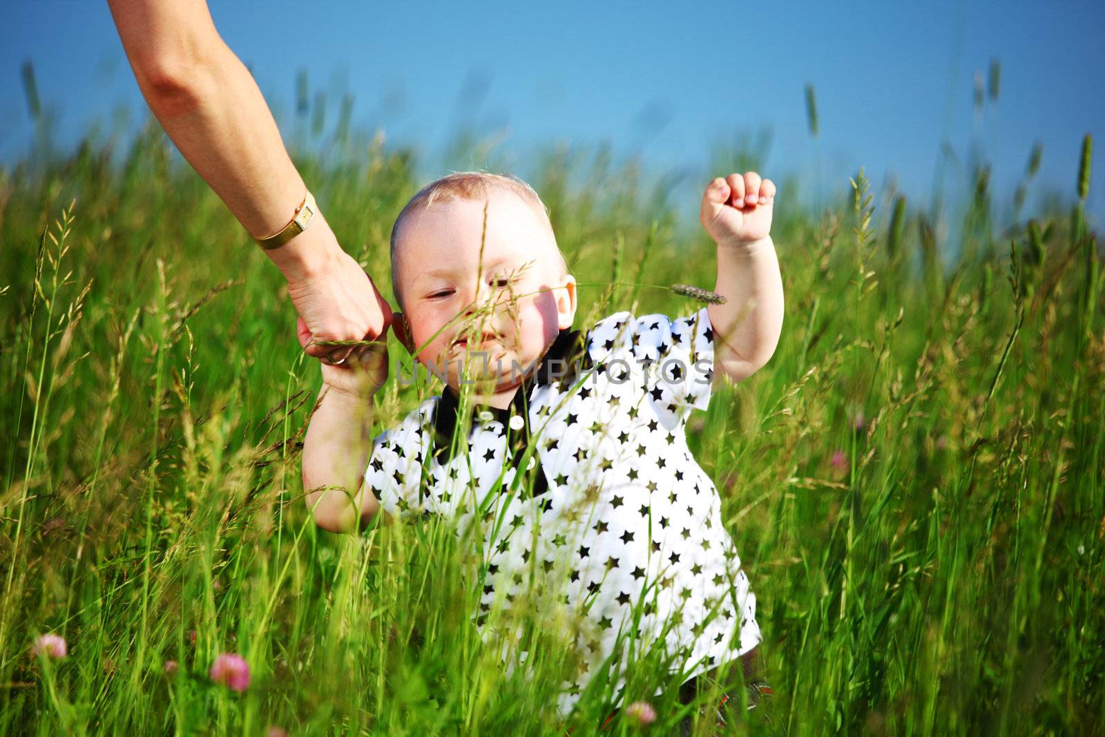 boy and mother hands in grass field
