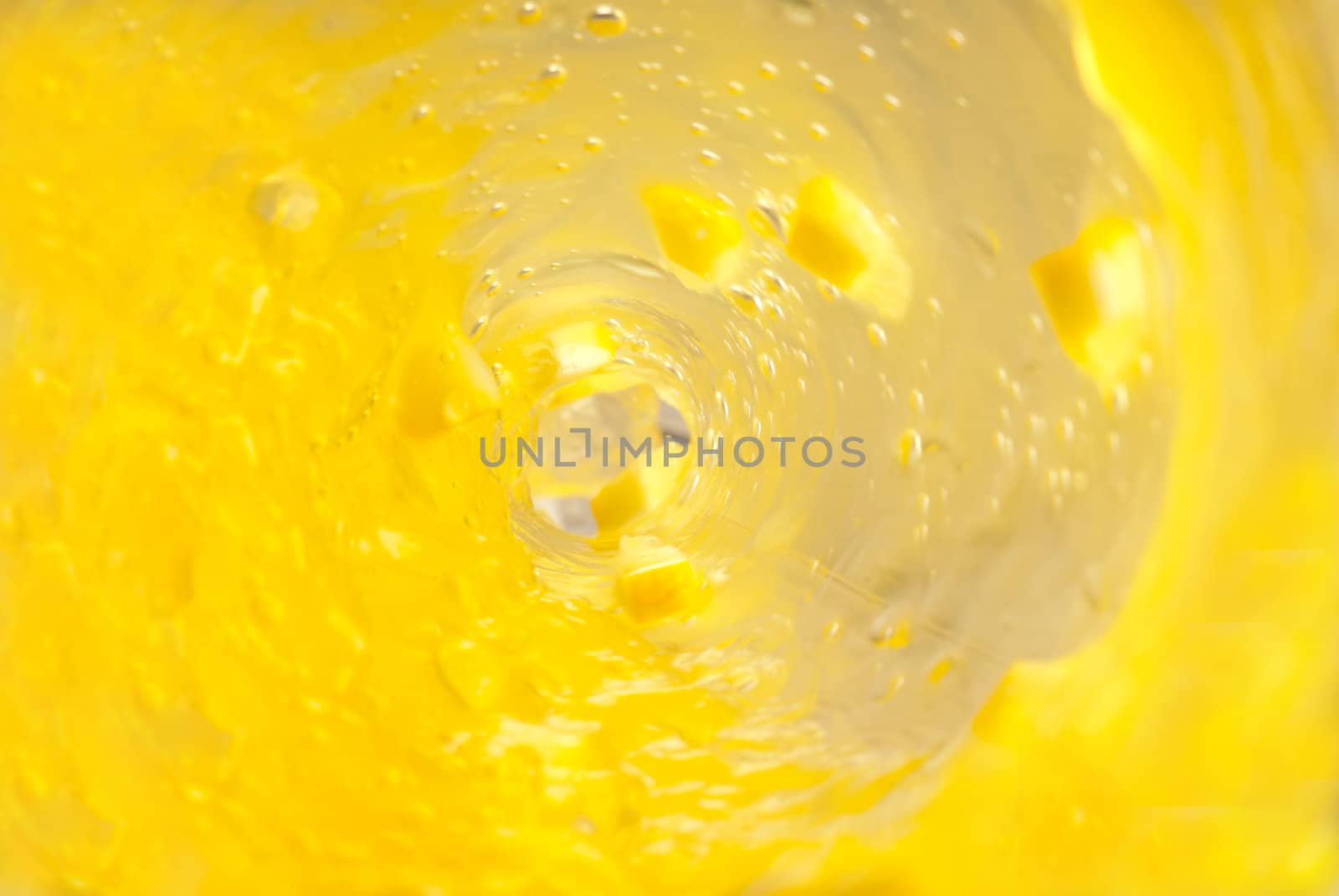 Smooth flow of a yellow lemon juice out of a bottle