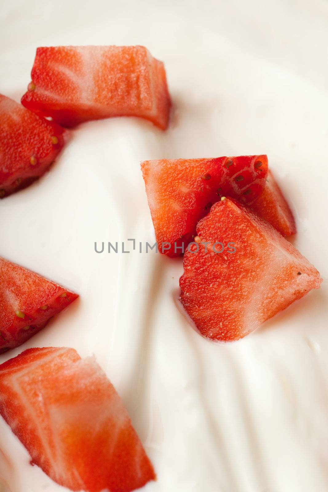 Contrasty strawberry pieces on a white cream