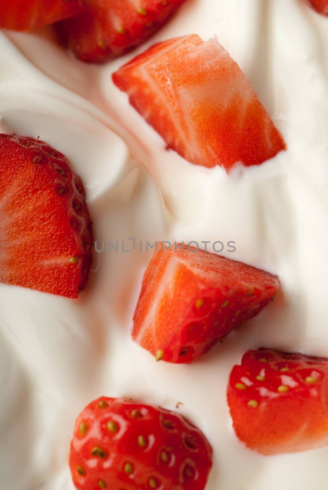 Sliced red strawberry in white cream