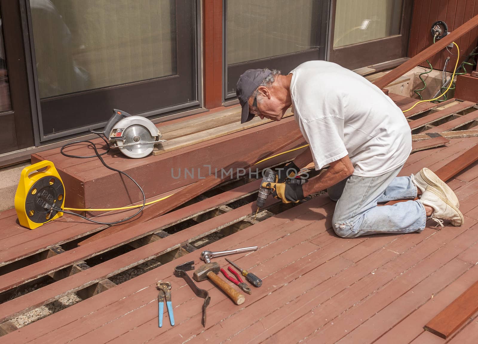 Senior repairing mahogany wooden deck