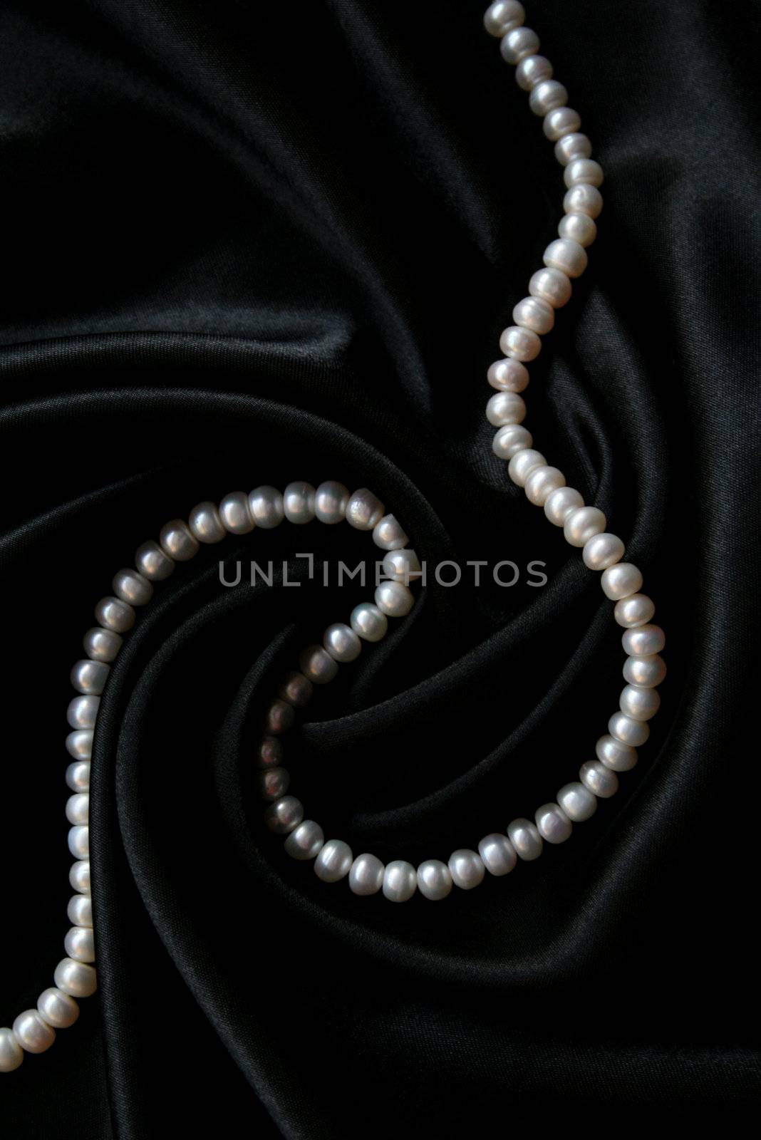 White pearls on the black velvet background 