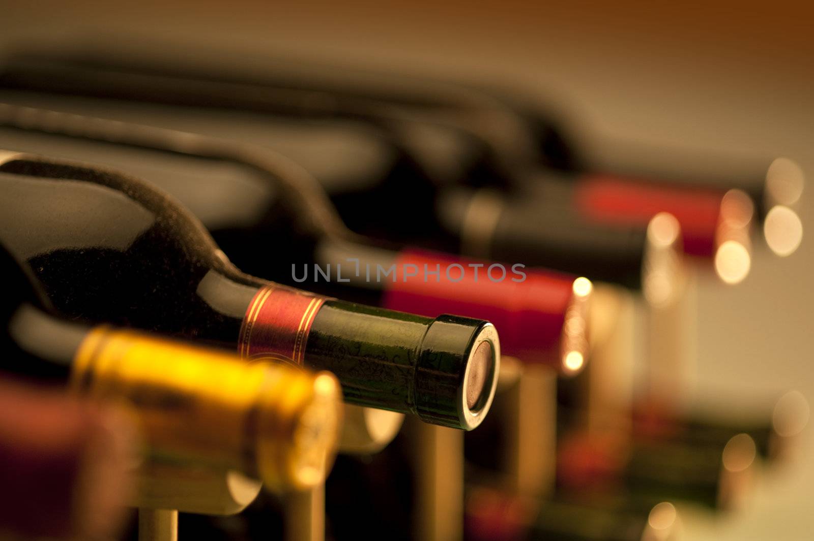 Red and white wine bottles stacked in a wooden rack by f/2sumicron