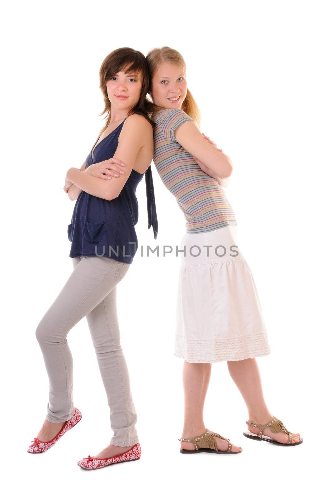 Two smilling girls are standing back-to-back on white background