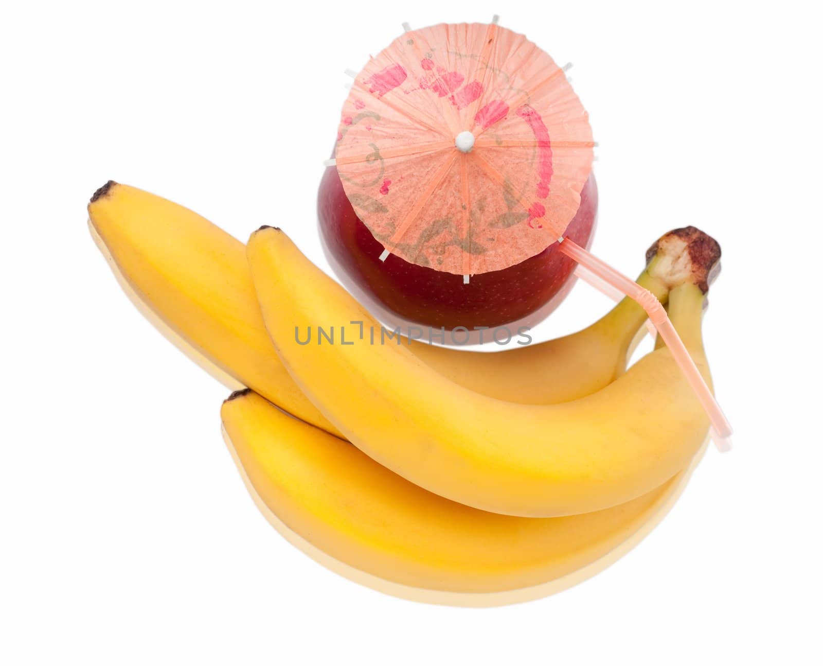 Bunch of fresh bananas and red apple with coctail umbrella isolated on white background. Shallow depth of field.