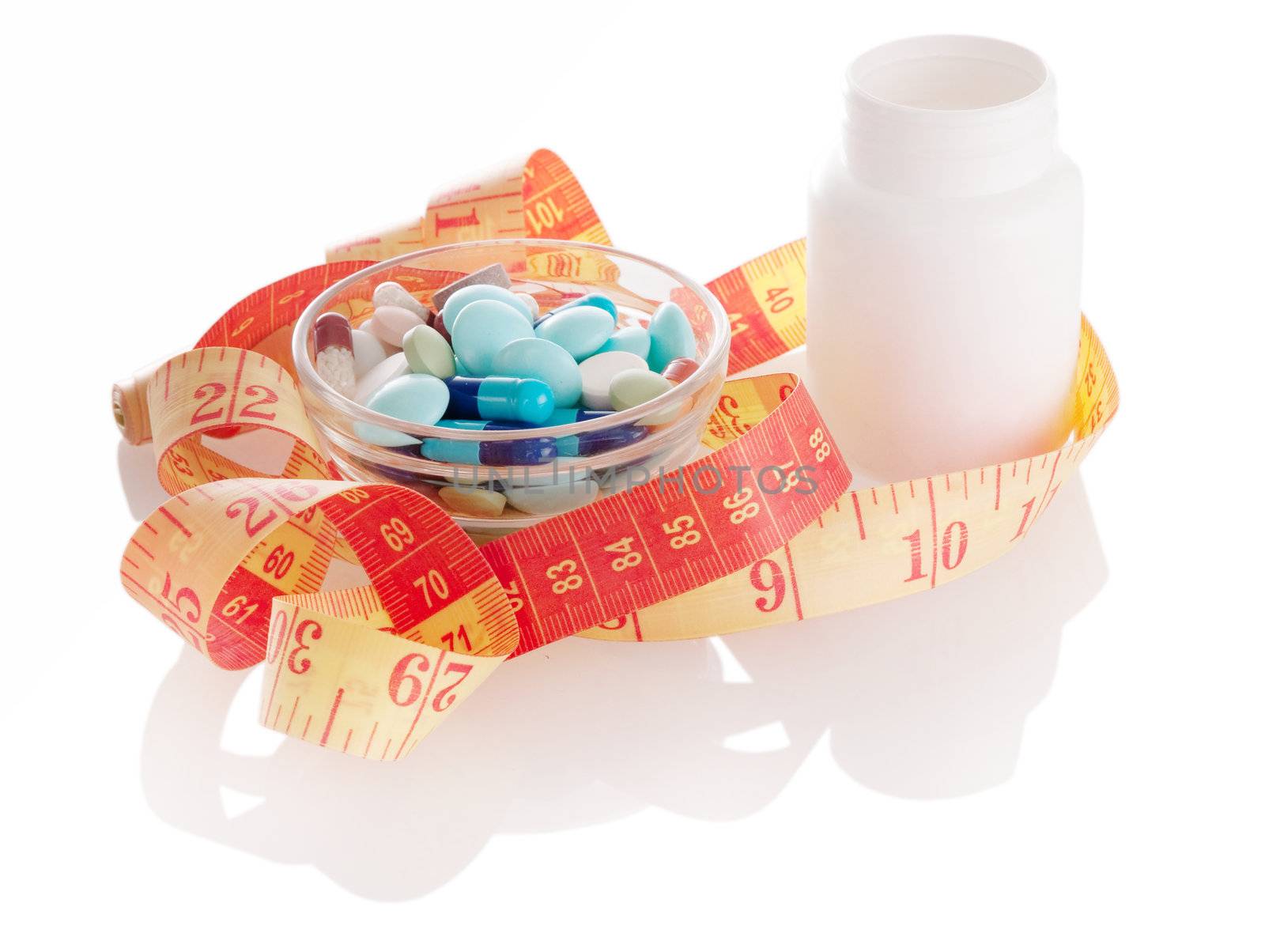 Different pills with white bottle and measurint tape with soft shadow on white background