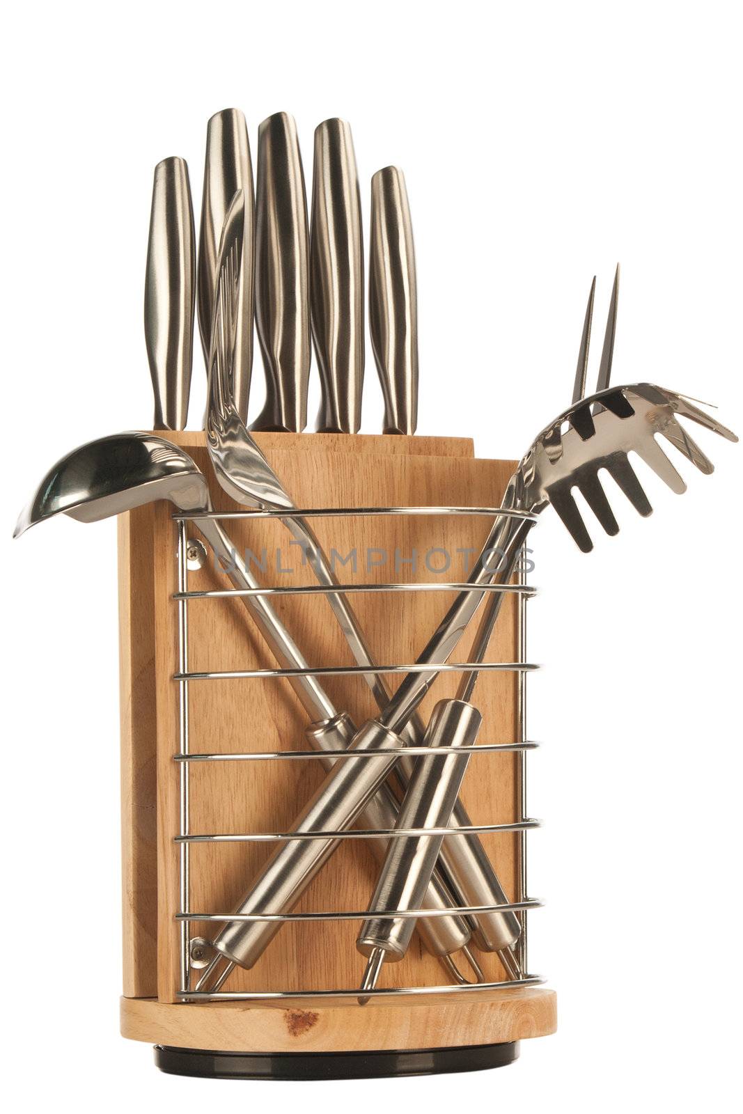 Silver kitchen utensils including whisk, tong and spoon on a white background and knife set