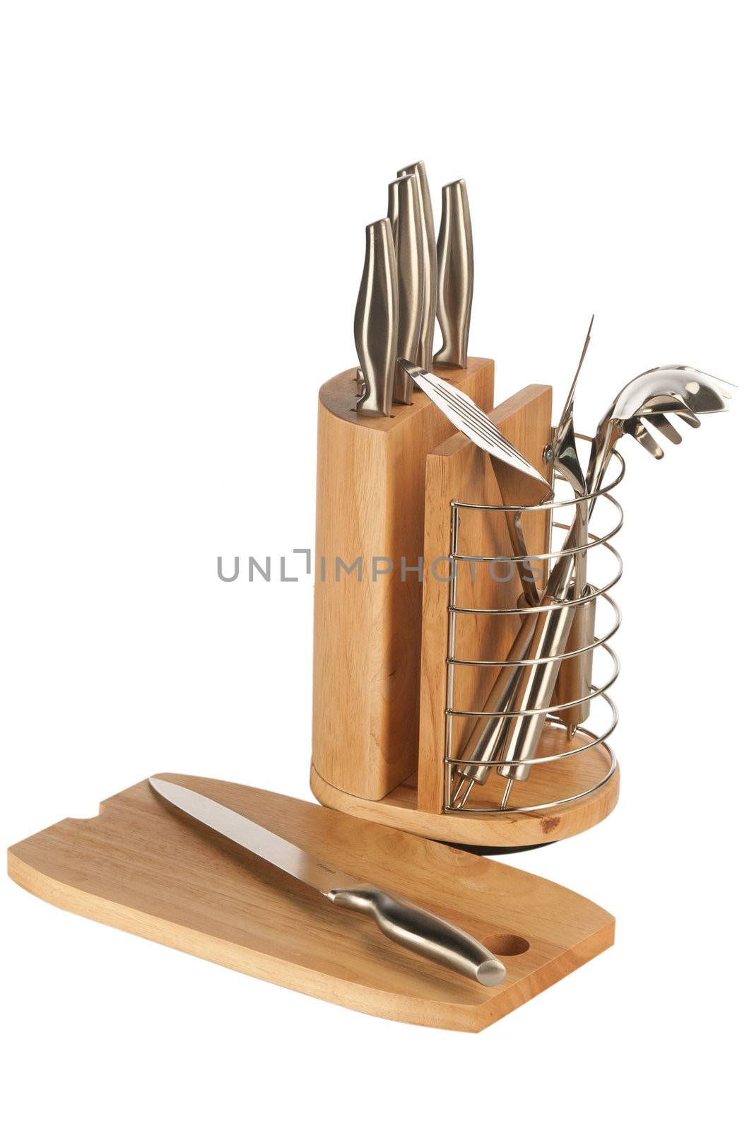 Silver kitchen utensils including whisk, tong and spoon on a white background and knife set