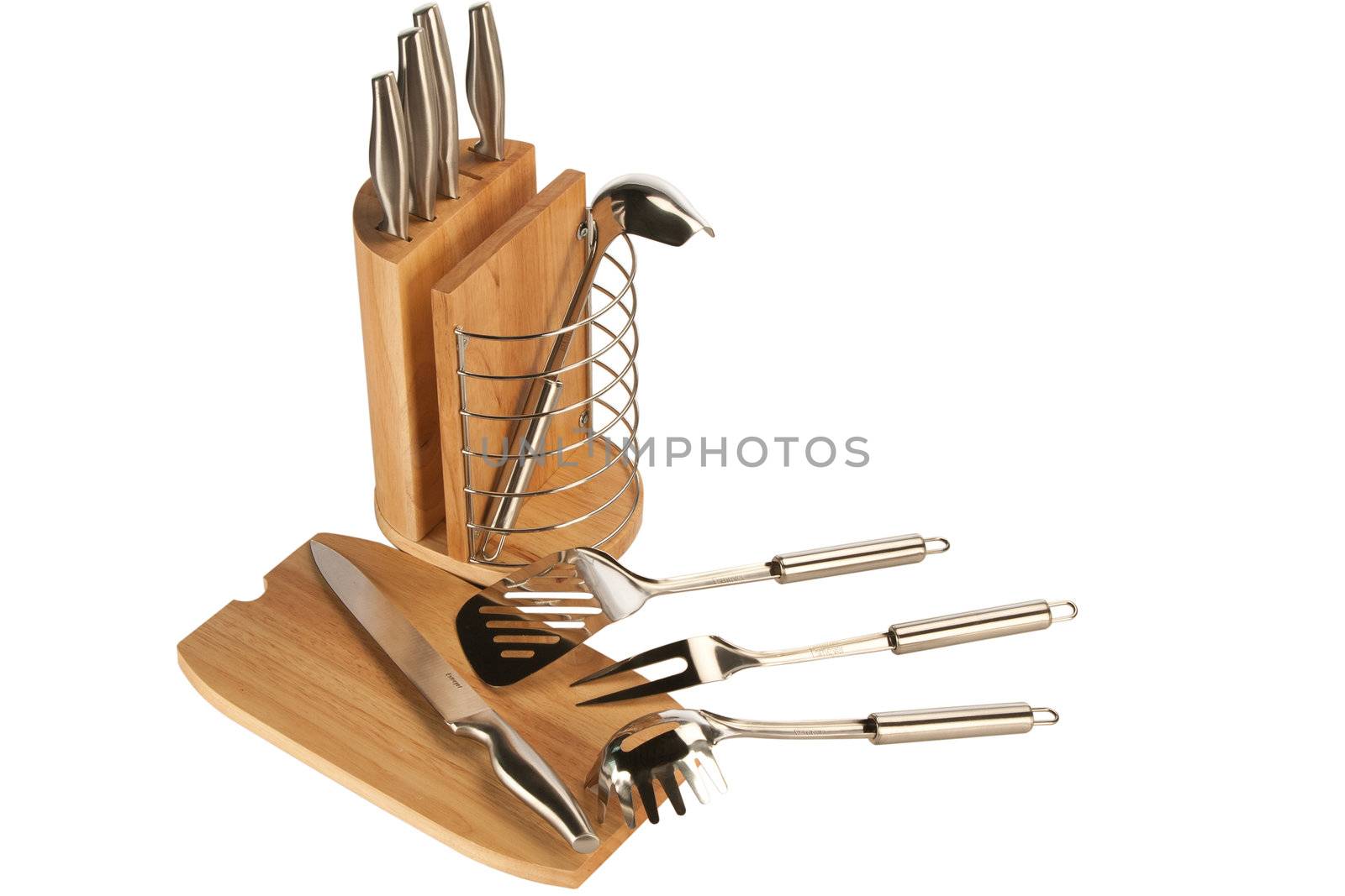 Silver kitchen utensils including whisk, tong and spoon on a white background and knife set