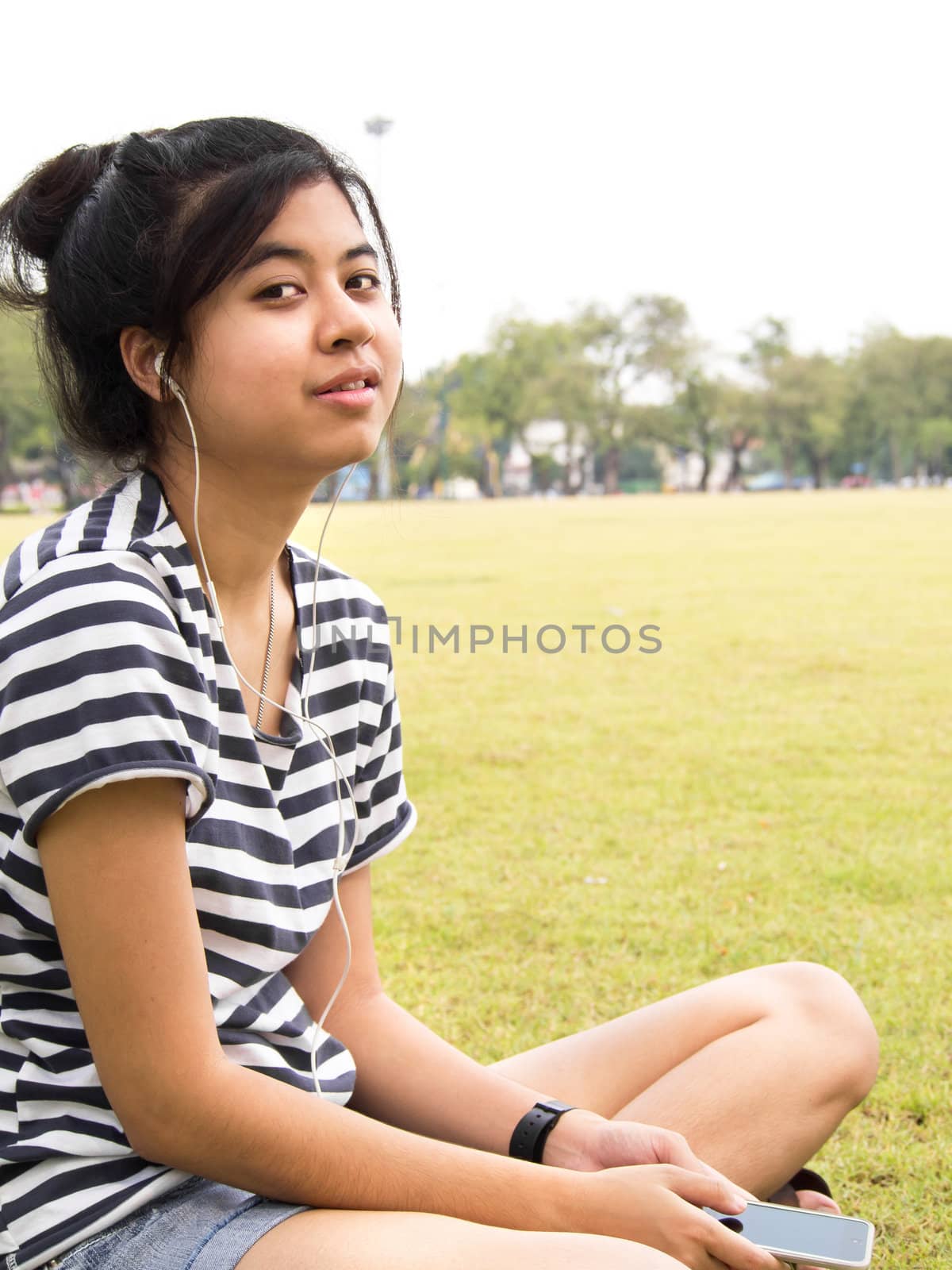 A young girl with headphones outdoors. Listening music 