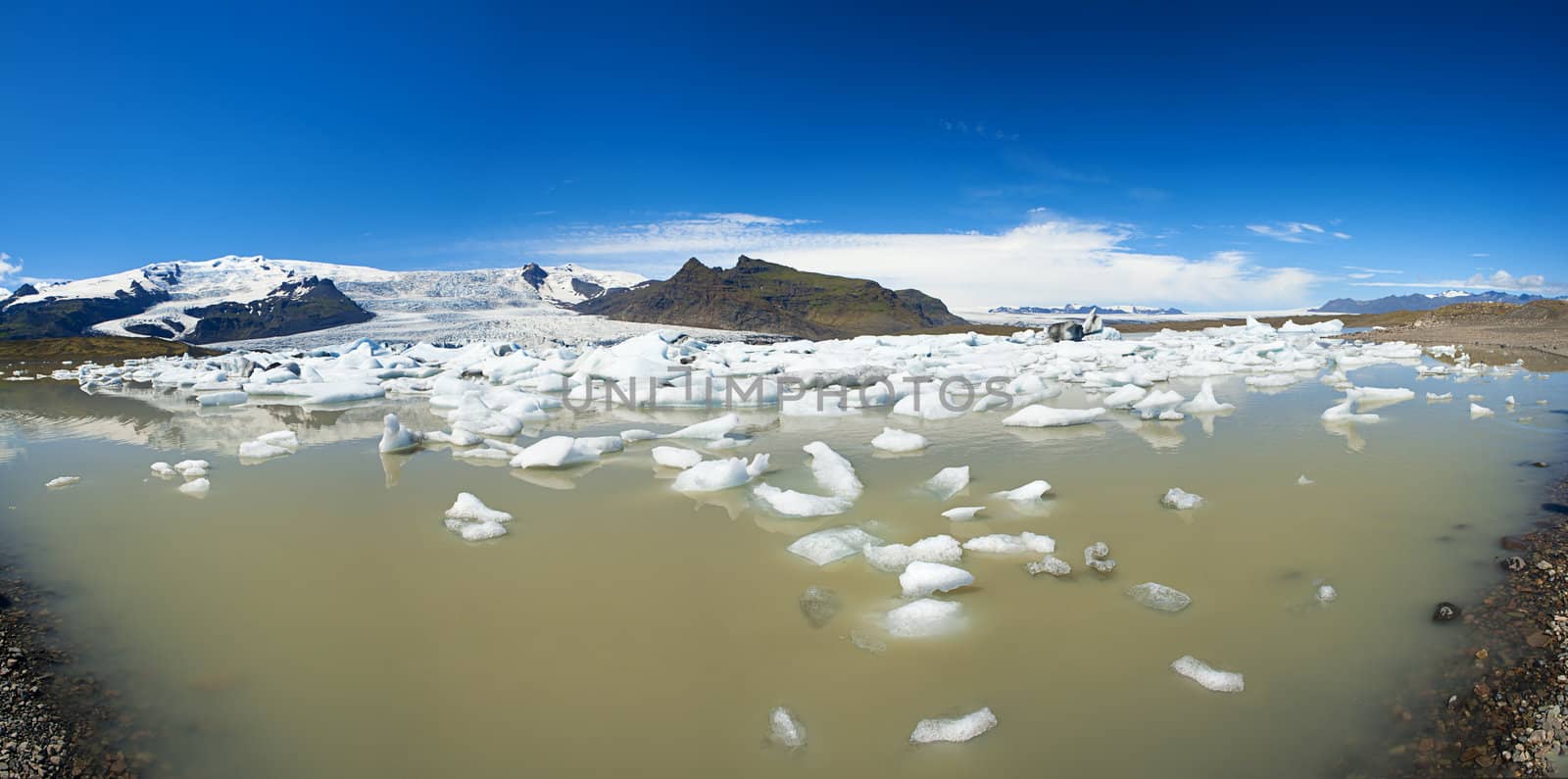 Beautiful panoramic photo of Fjallsarlon Glacial lake full of floating icebergs near the Fjallsjokull glacier