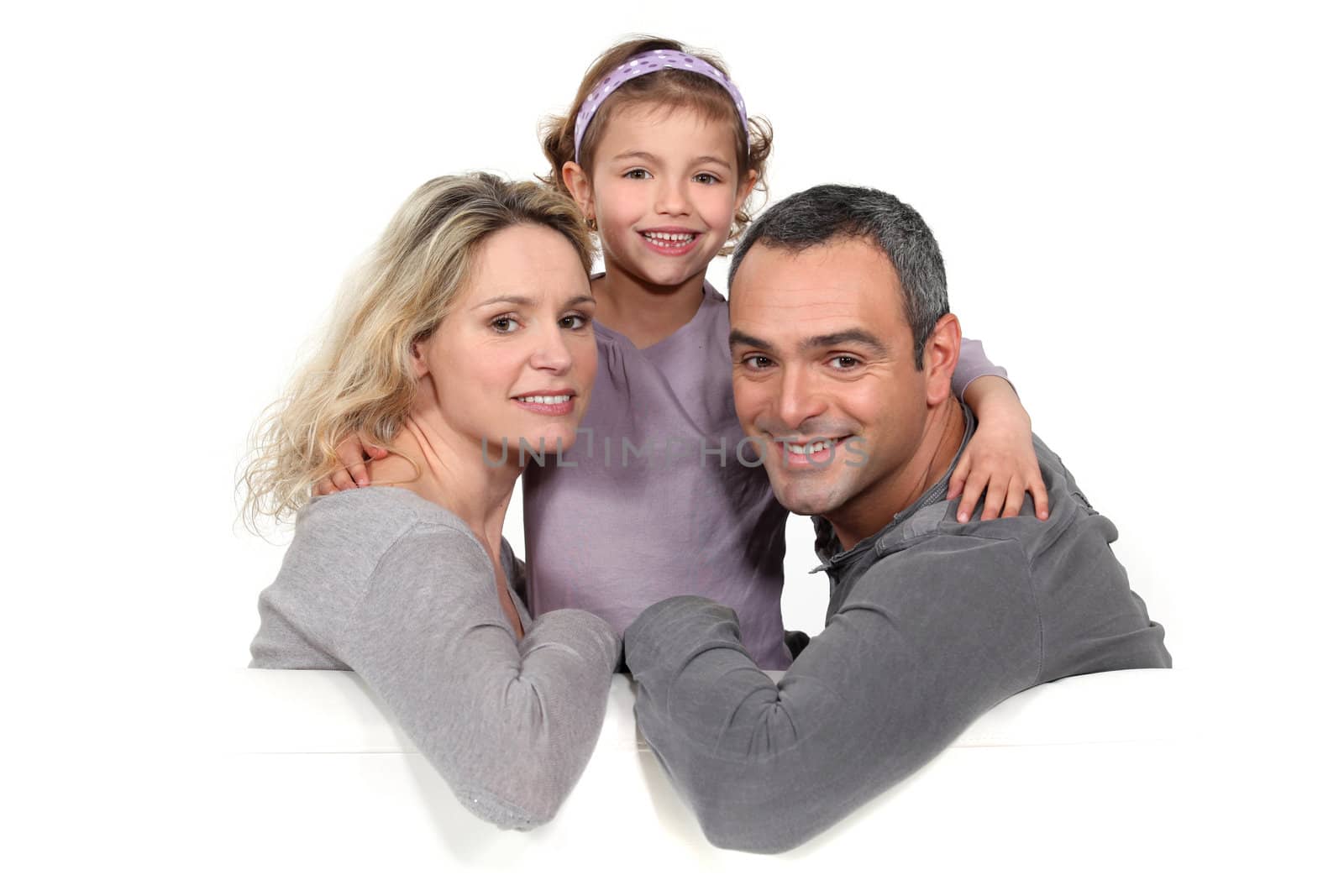 portrait of couple with daughter against studio background by phovoir