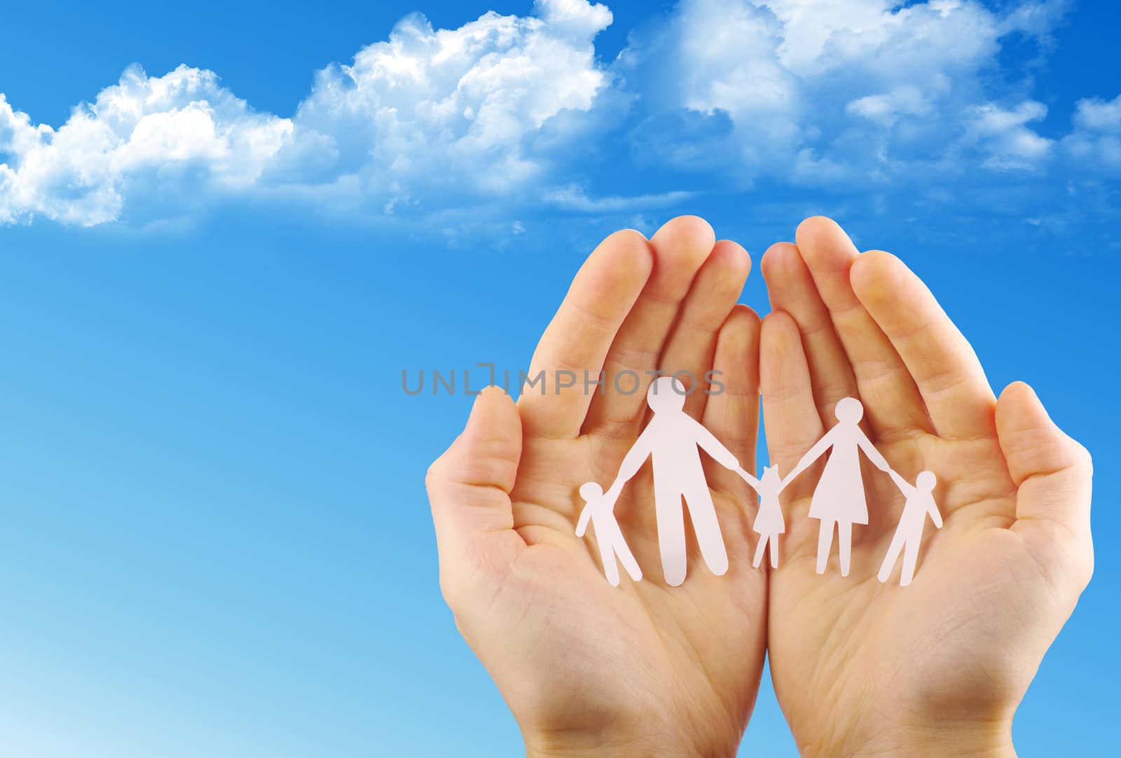 Paper family in hands isolated on blue sky
