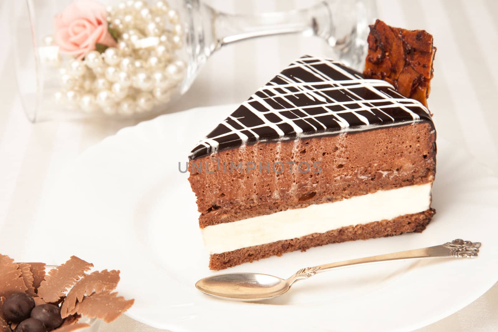 chocolate cake on the white plate with a silver spoon