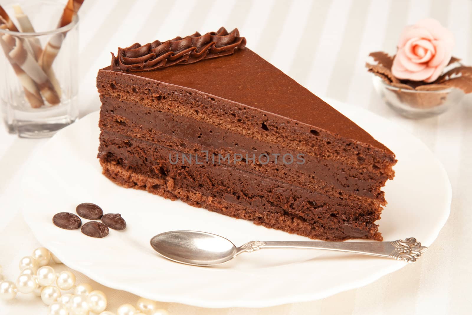 chocolate cake on the white plate with a silver spoon