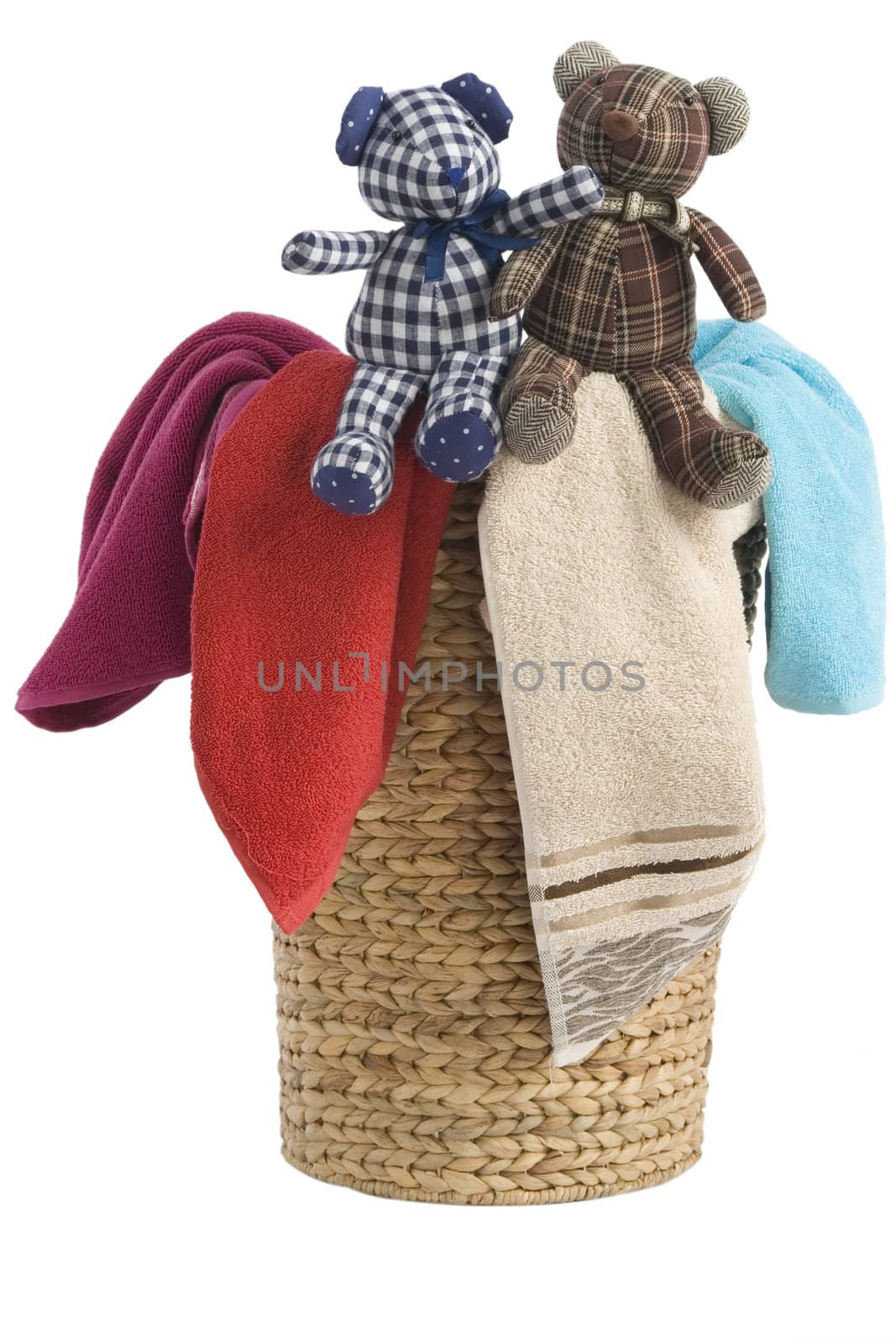 colorful towels in a basket isolated on white background and a resting teddy bears