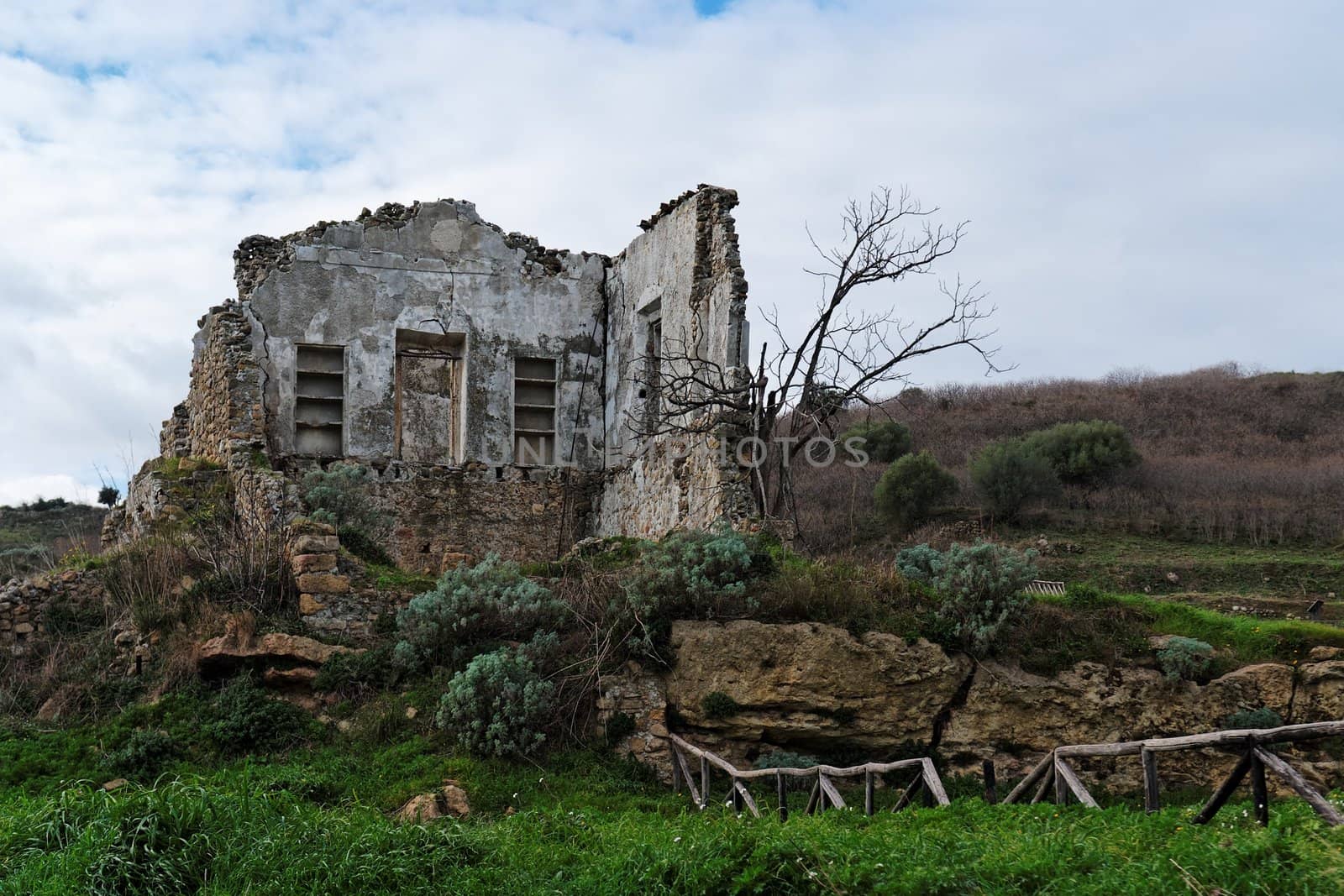 Farmhouse ruin among rural landscape